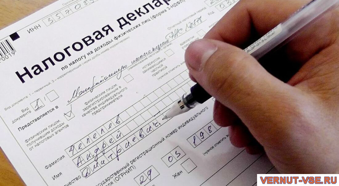 Ручка в мужской руке над декларацией 3-НДФЛ
